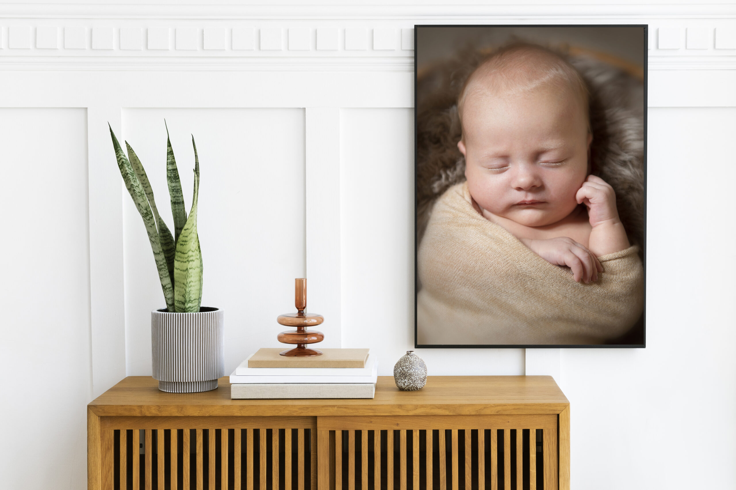 Picture frame mockup hanging above a wooden cabinet