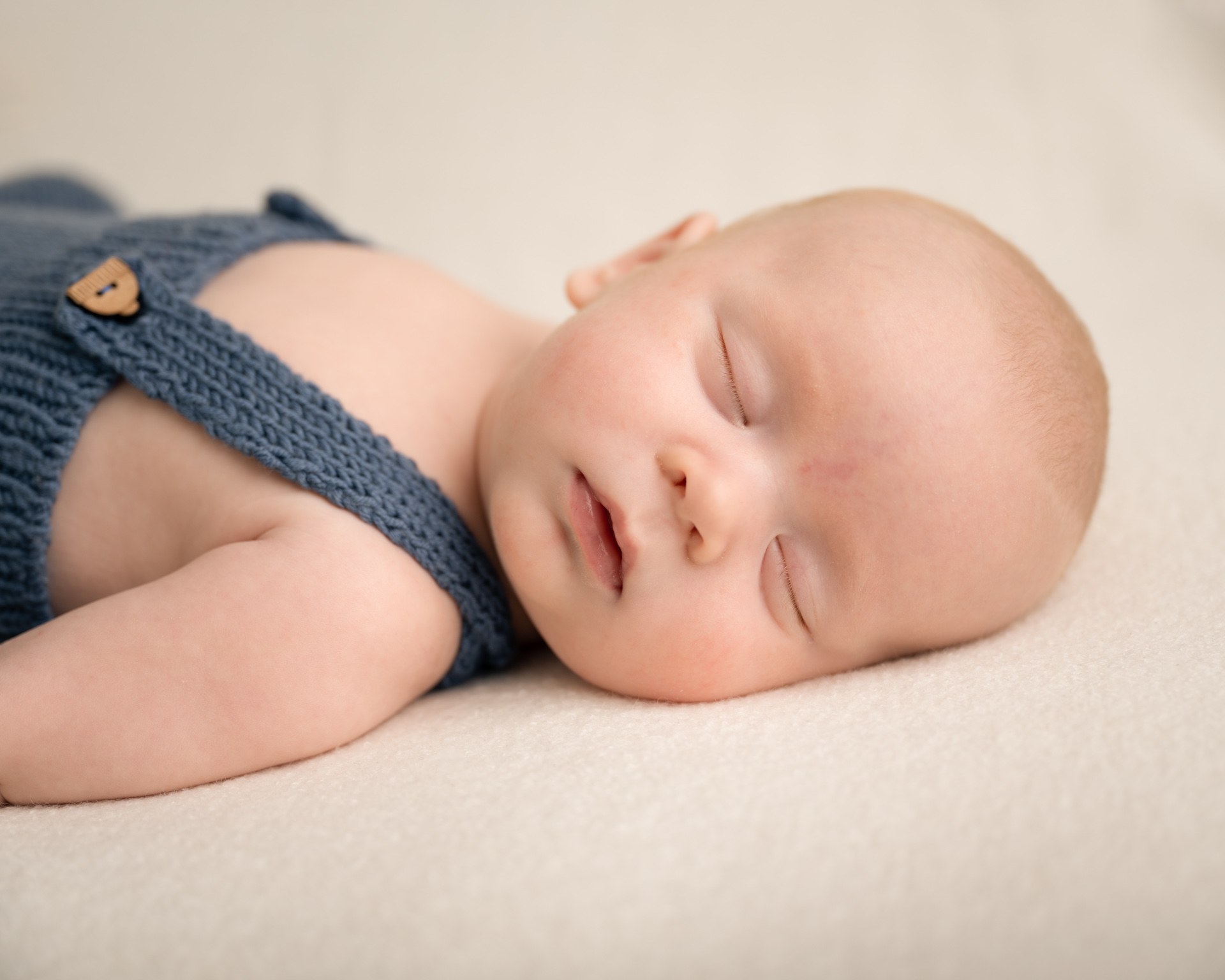 Sovende baby med flå strikket selebukse.